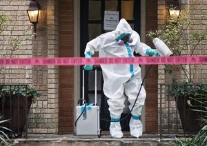 A member of the CG Environmental HazMat team disinfects the entrance to the residence of a health worker at the Texas Health Presbyterian Hospital who has contracted Ebola in Dallas